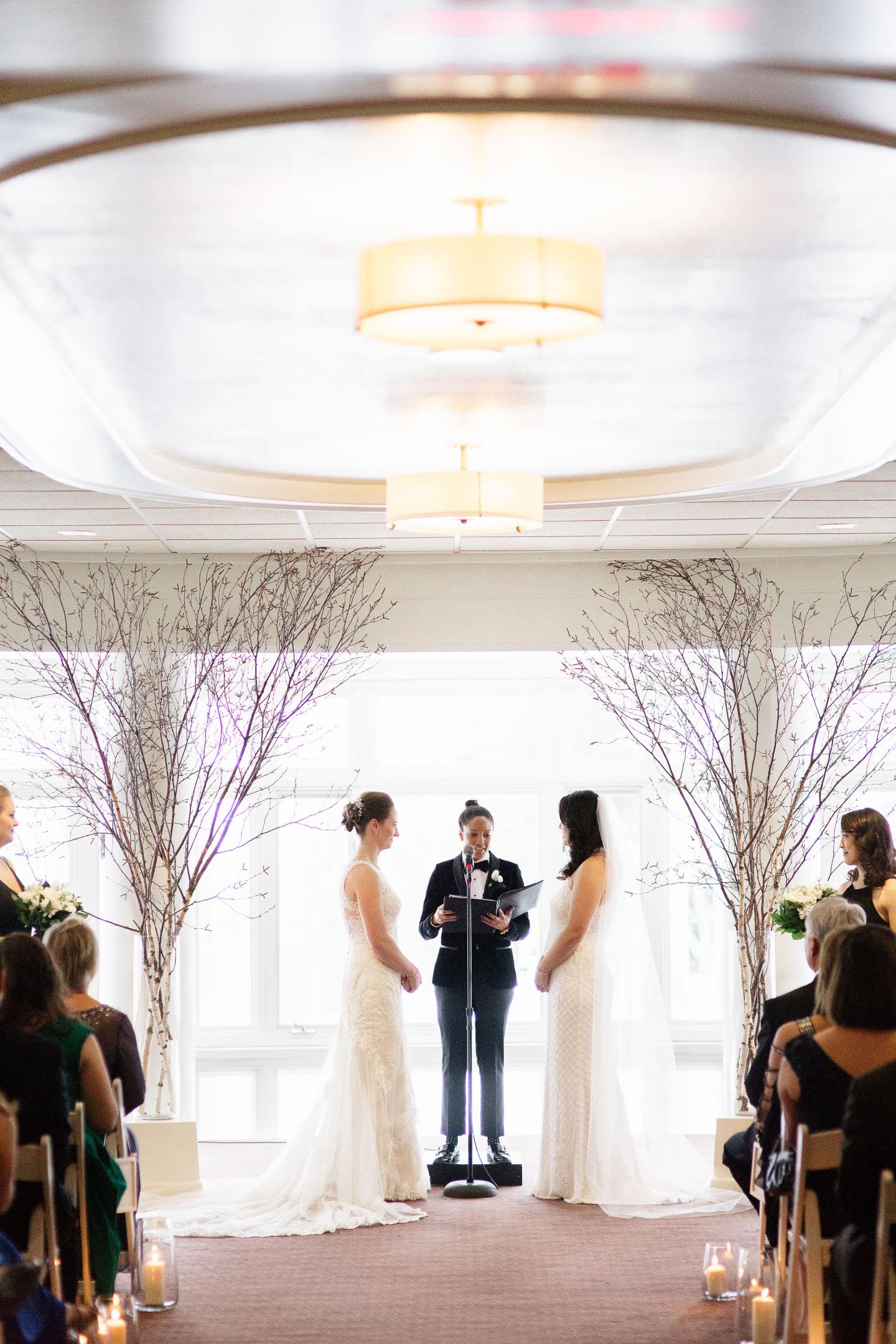 Two brides under the arbor during wedding ceremony in the Rockefeller Room