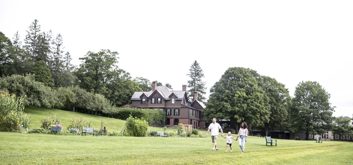 Family walks holding hands in front of the Billings Farm & Museum
