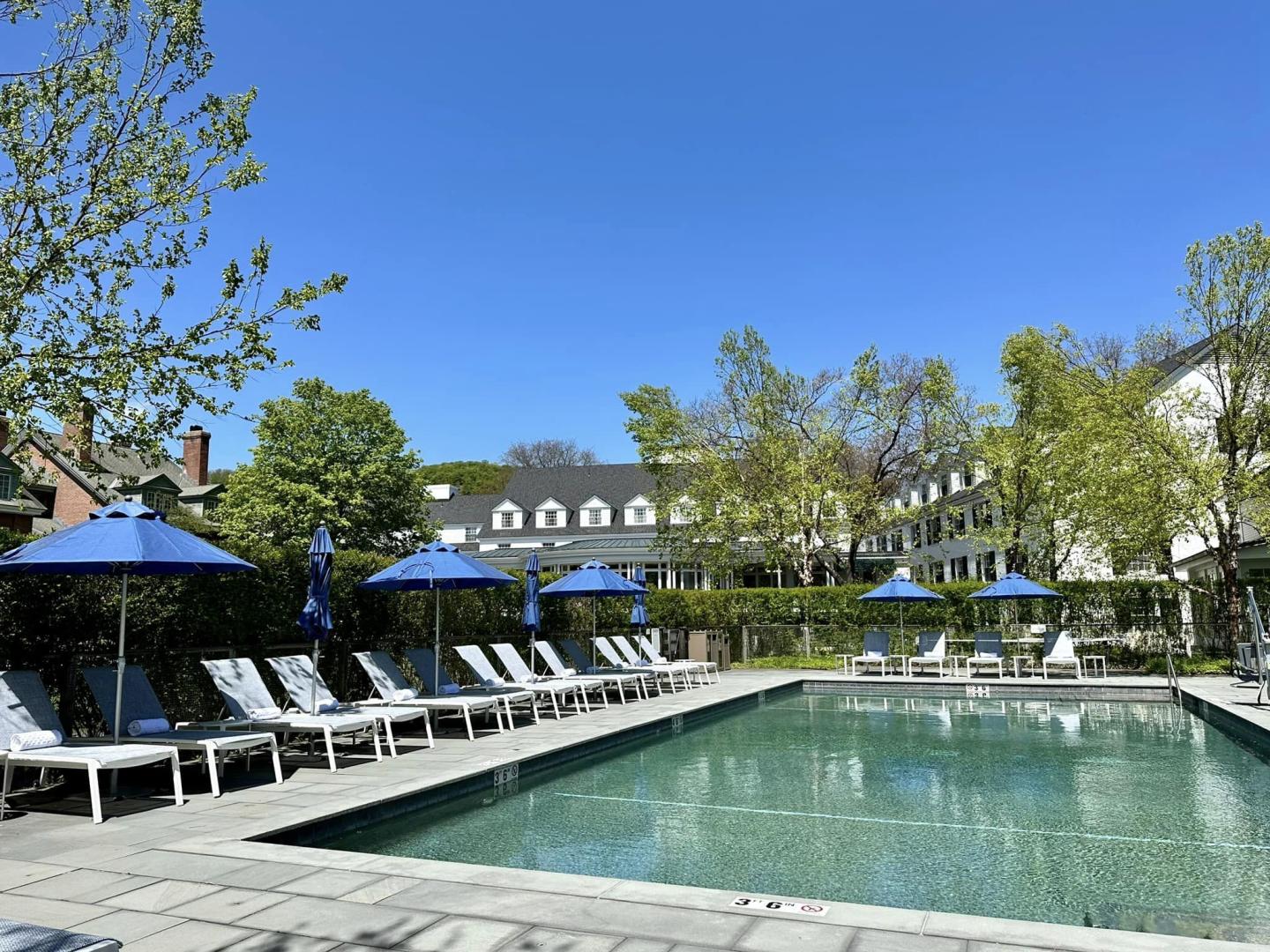 Woodstock Inn outdoor pool with blue umbrellas and chairs sitting on the edge of the pool