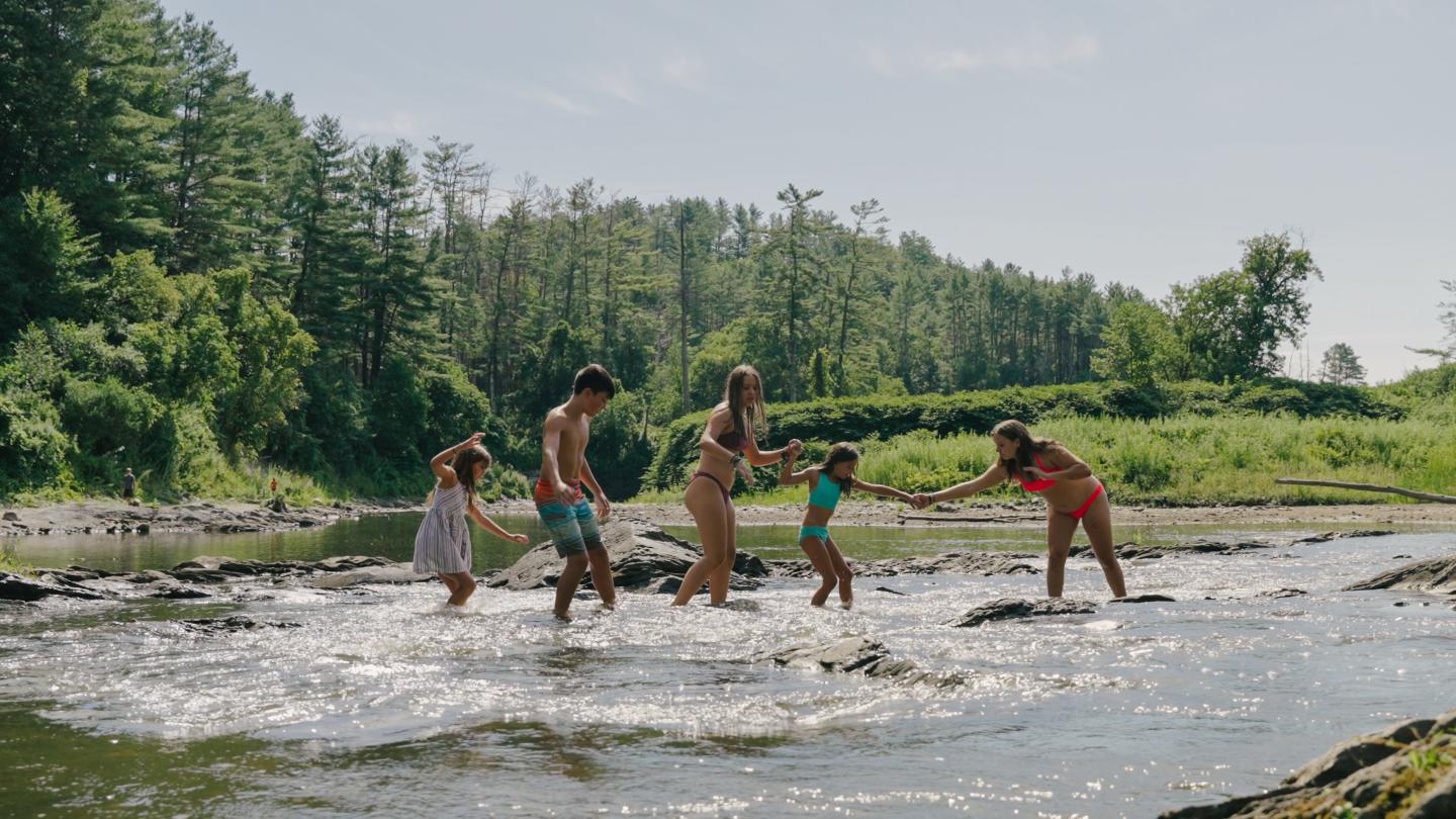 Five kids crossing the river in Quechee Vermont