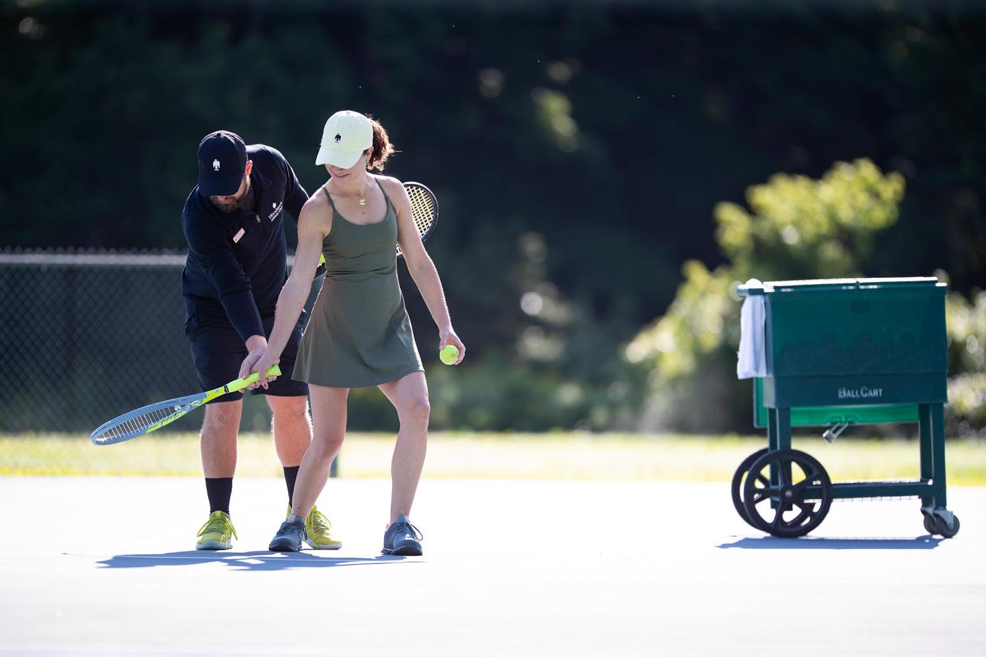 Woman with a tennis racket on the outdoor tennis courts.