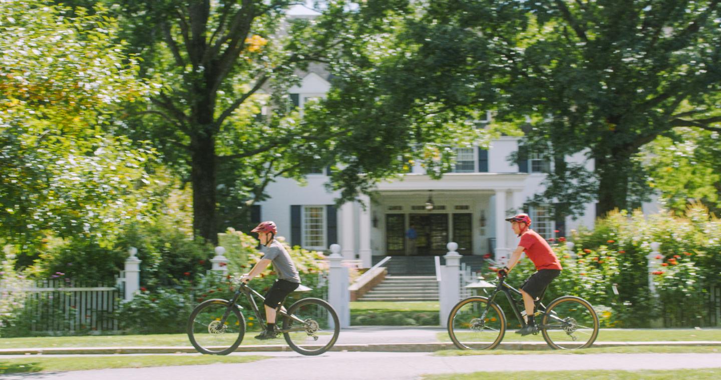 Two people biking in front of the Woodstock Inn