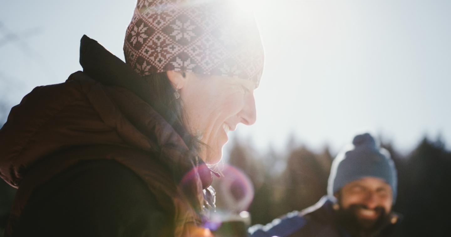 People in ski gear smiling and laughing outdoors