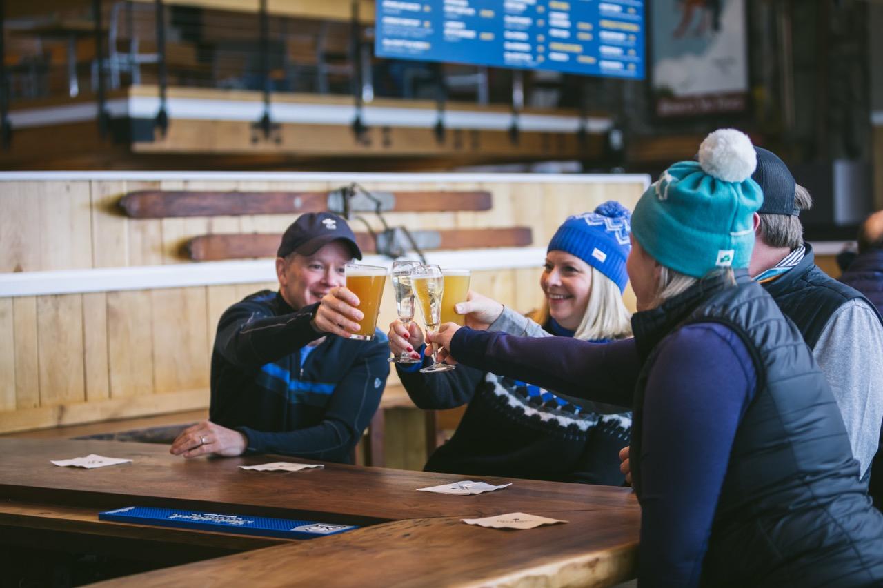 A group of people clinking glasses in cold weather gear at S6