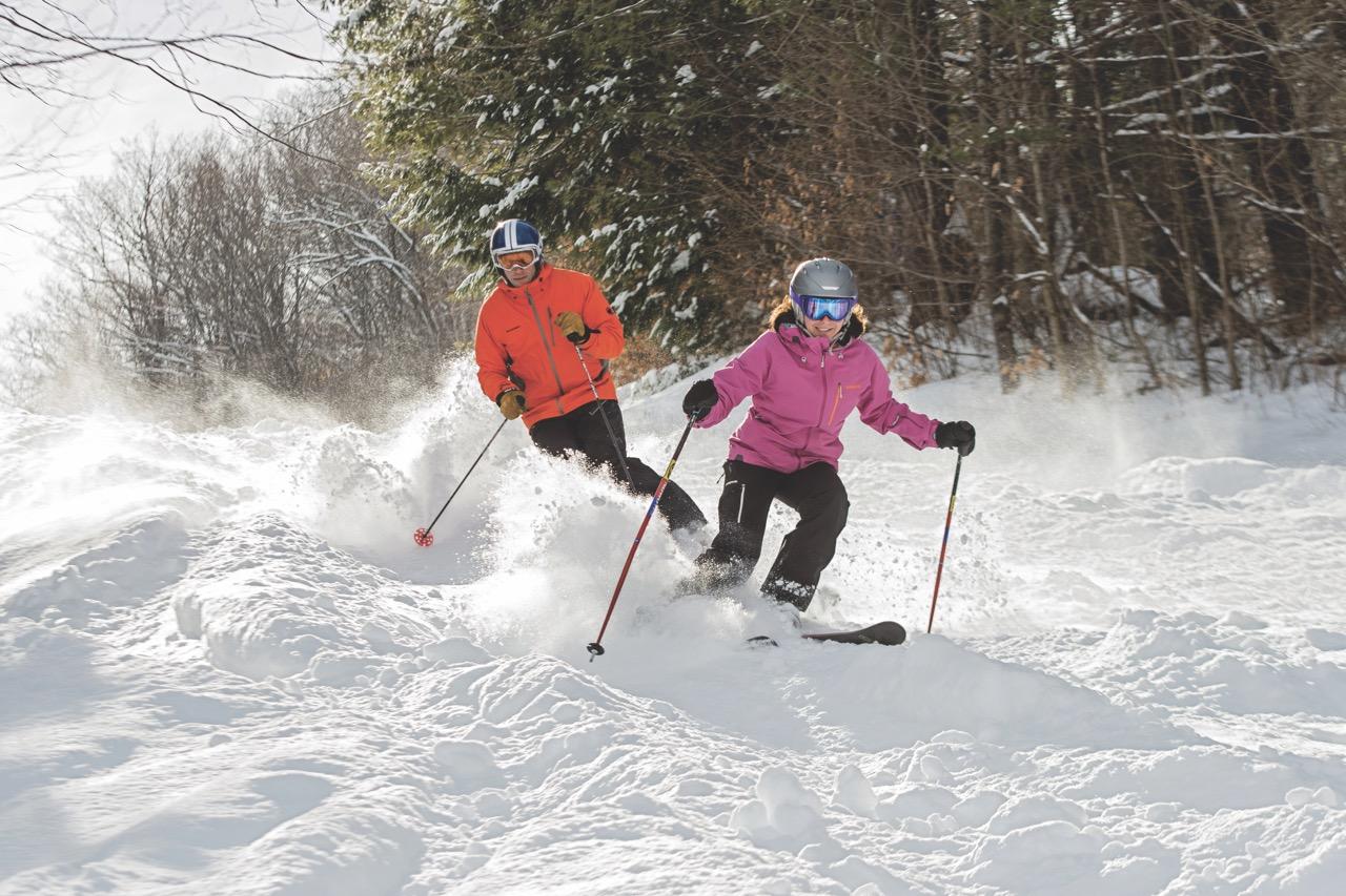 A Ski Couple at Saskadena Six Skiing Side by Side