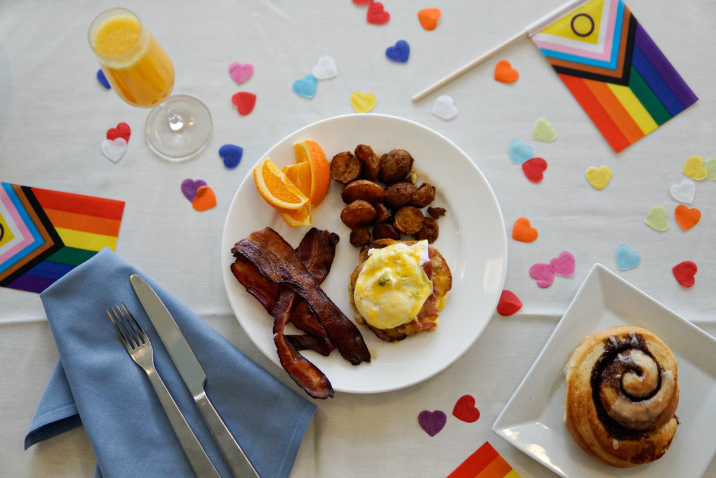 Brunch plate and a mimosa with rainbow confetti and pride flags