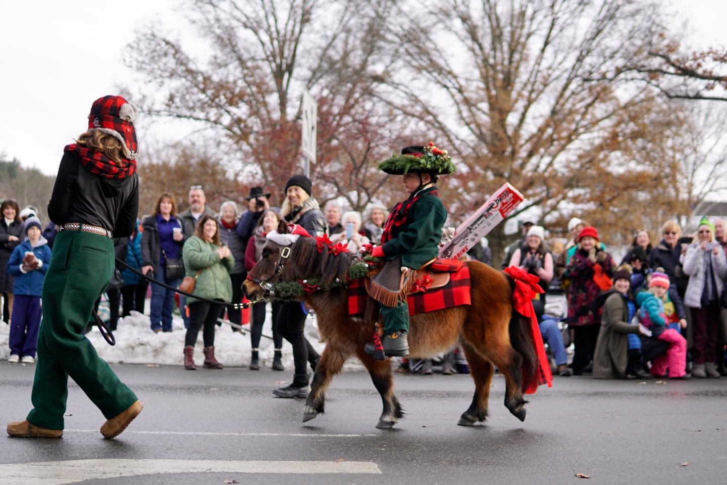 Small pony with a little boy rider dressed in red and black plaid