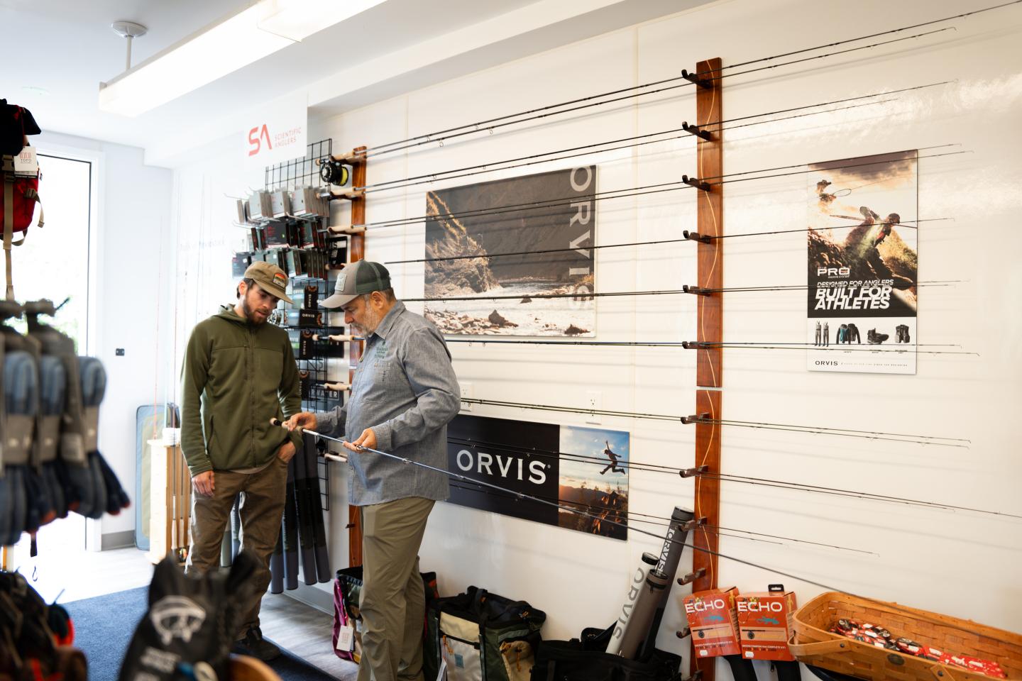 Two people looking at Orvis rods in the Activity Center