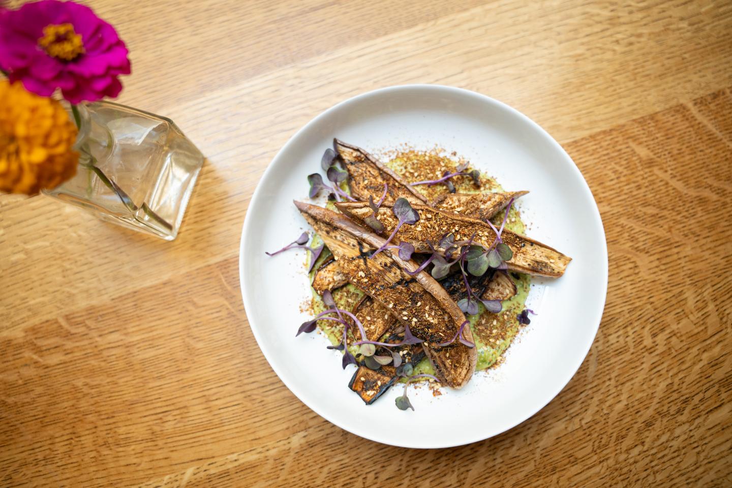 Eggplant with spices on a white plate
