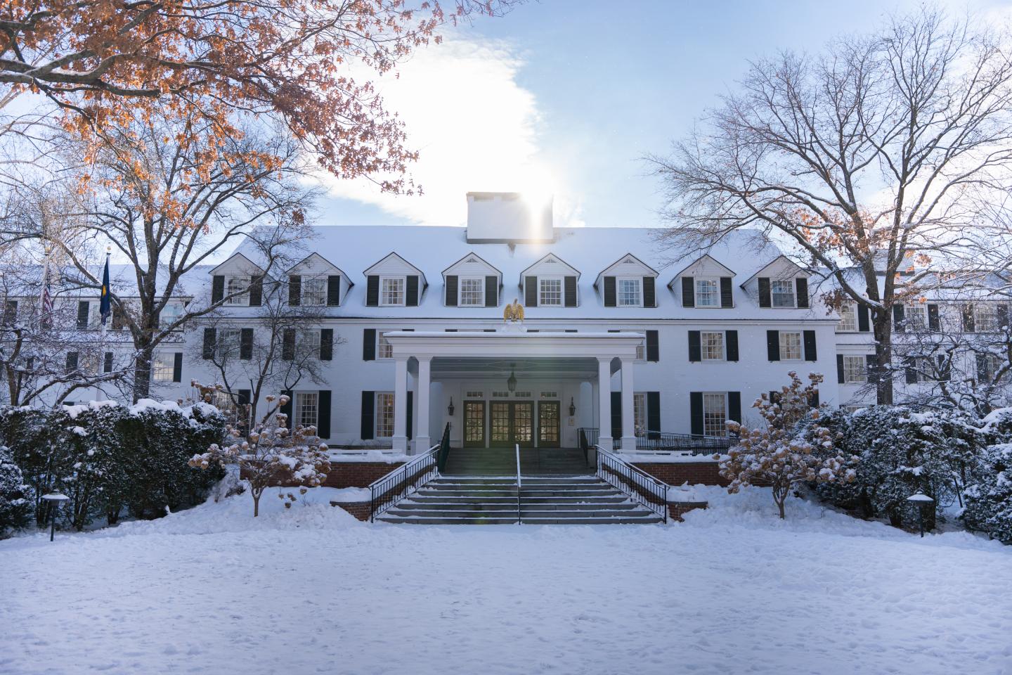 Front of Inn covered in snow on a sunny day