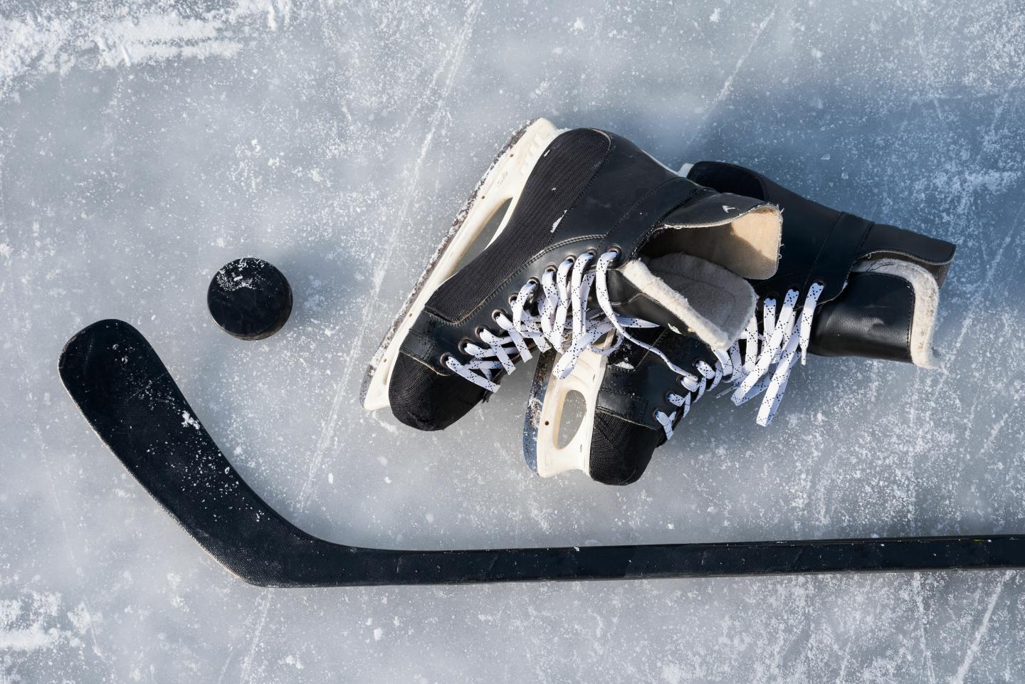 Hockey skates and stick on ice