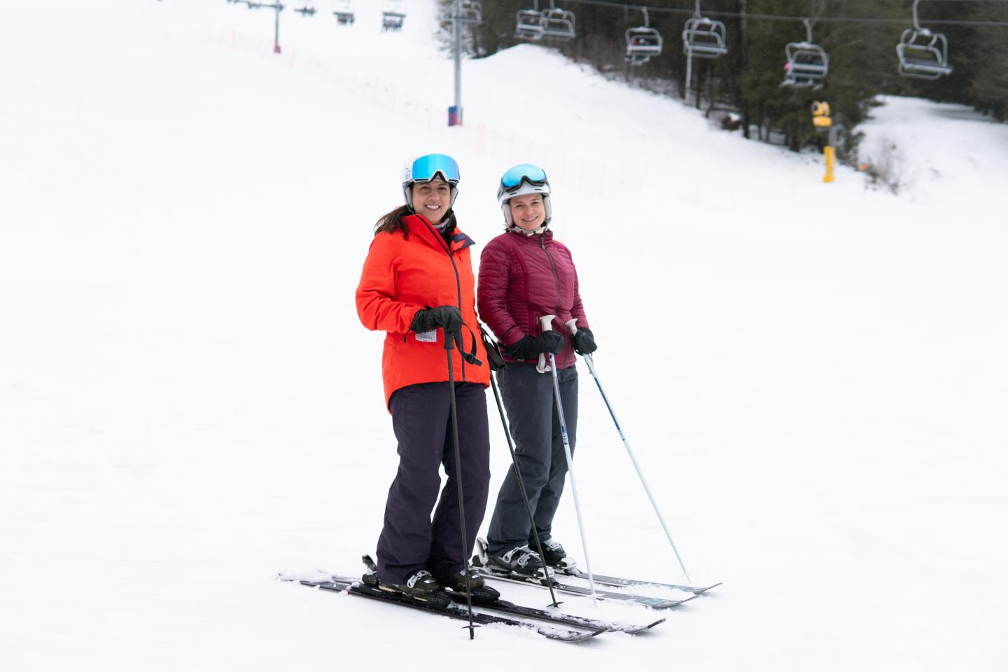 Friends smiling on the ski hill in full gear