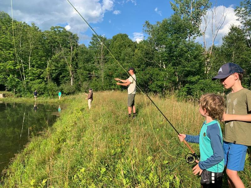Family fly fishing in a pond