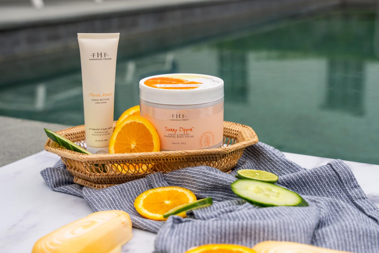 Spa products with orange slices and cucumber, near poolside.