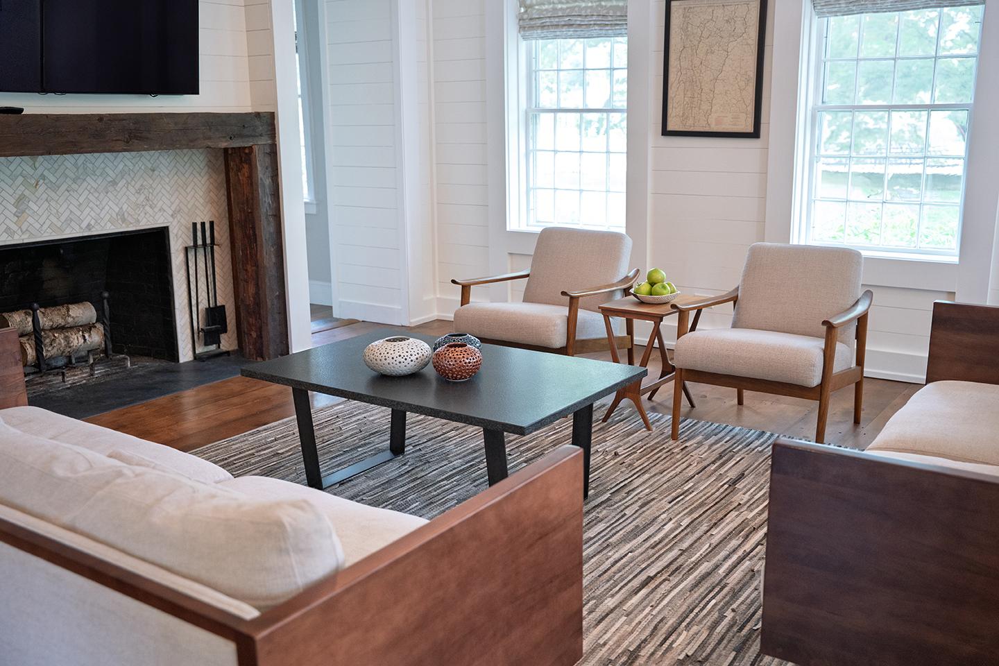 Cozy living room with modern decor, fireplace, and large windows.