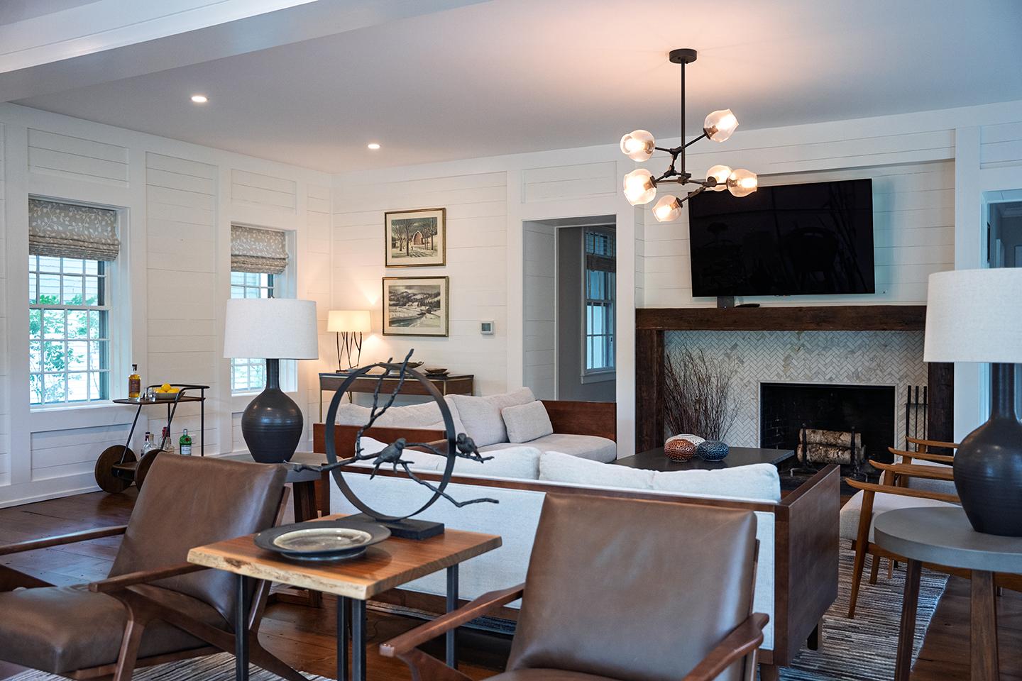 Cozy living room with modern chandelier, fireplace, and neutral tones.