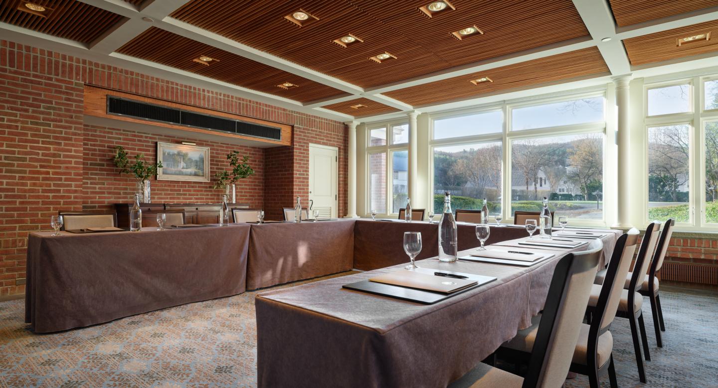 Conference room with U-shaped table setup and large windows.