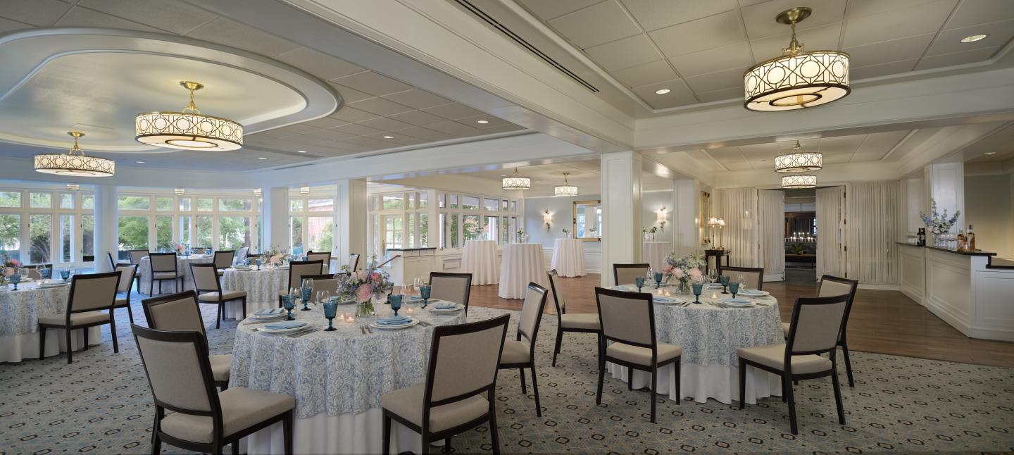 Elegant banquet hall with round tables and chandeliers.