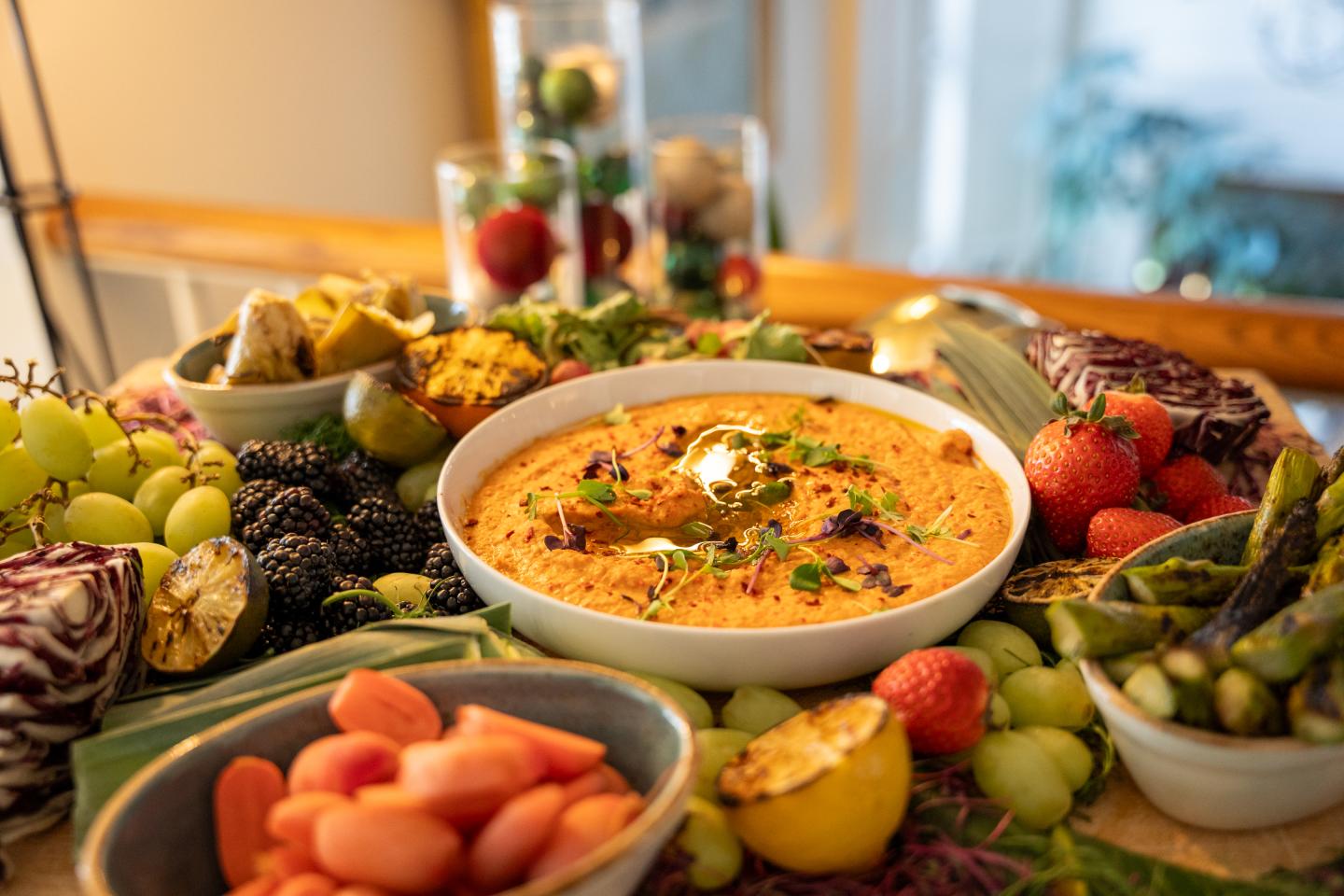 A colorful vegetable platter with a central bowl of dip.