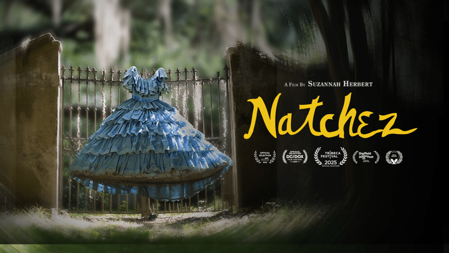 Blue ruffled dress displayed outdoors near an iron fence, with a dark, moody backdrop.