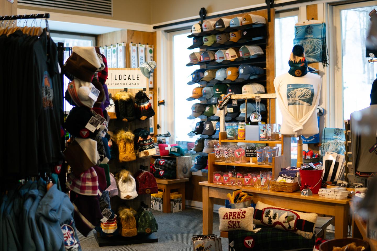Store interior with hats, shirts, and souvenirs on display.