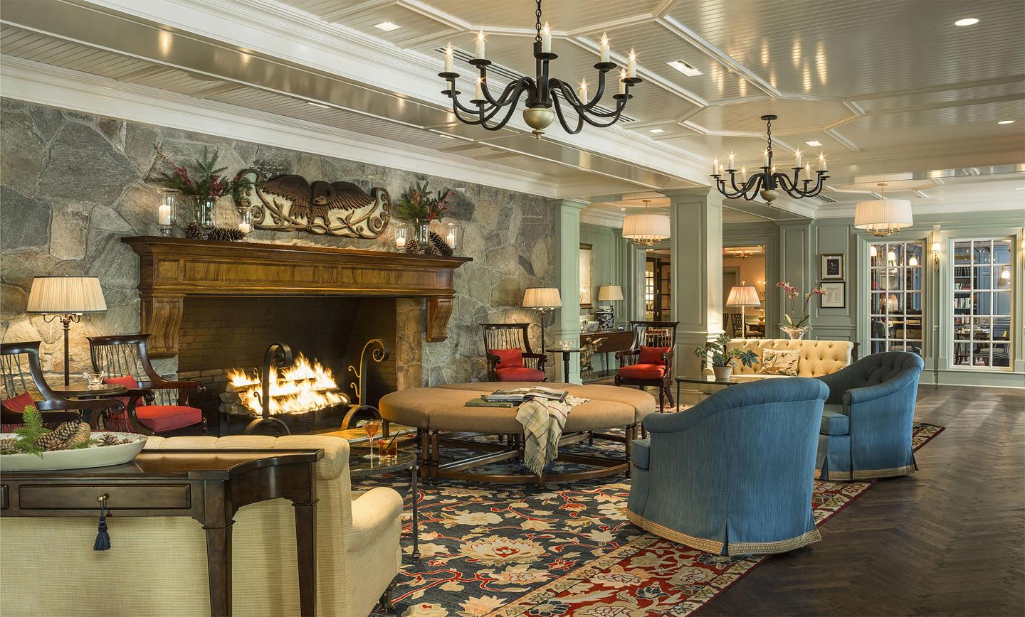Cozy lounge with a fireplace, armchairs, and chandeliers.