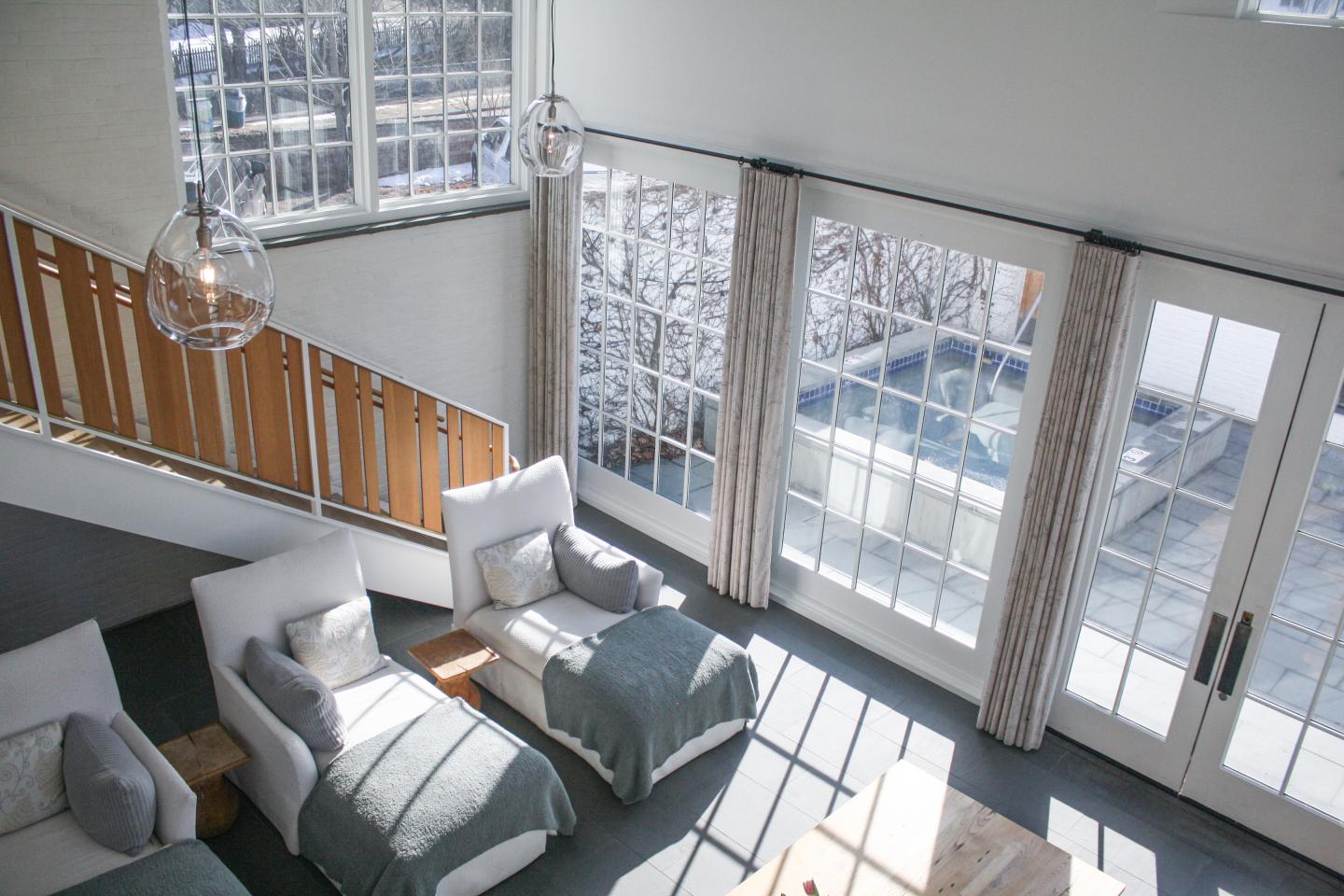 Bright living room with large windows, two armchairs, and a coffee table.