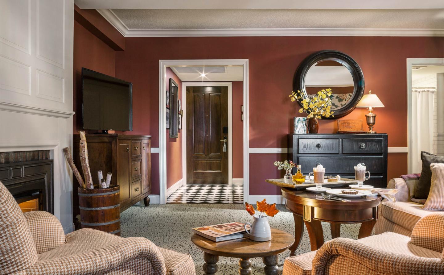 Cozy living room with red walls, beige furniture, and a wooden coffee table.