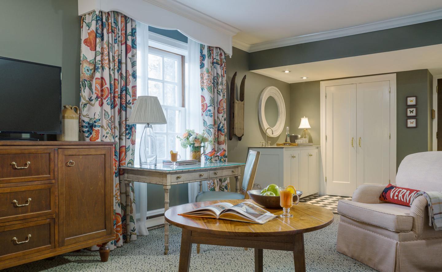 Cozy living room with a sofa, wooden table, and colorful curtains.