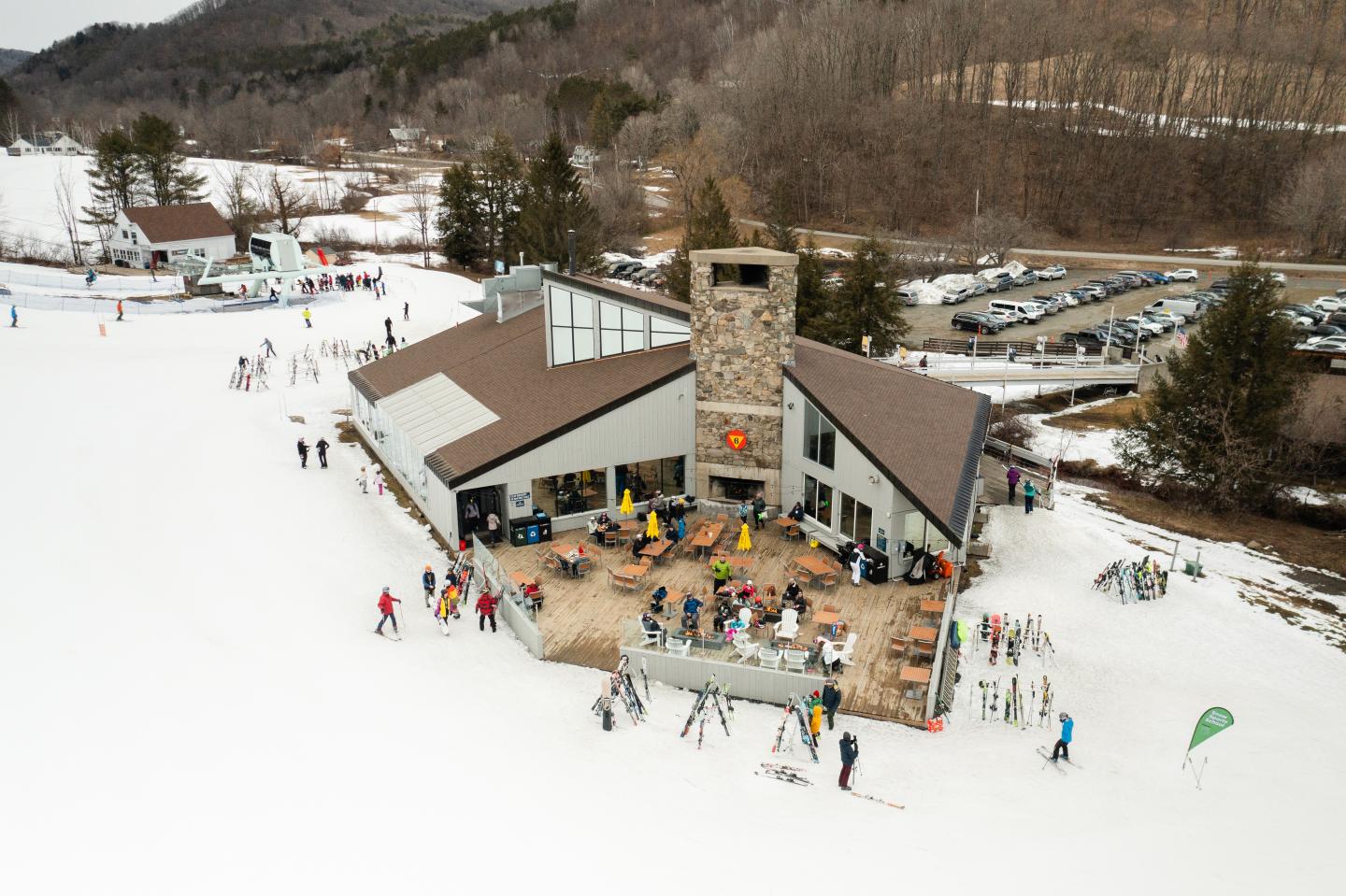 Ski lodge with people and skis on snowy mountain slope.