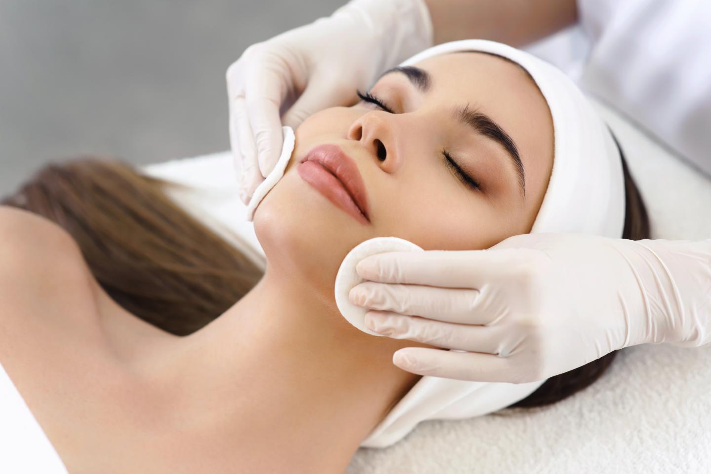 Woman receiving facial treatment. Relaxing spa setting.