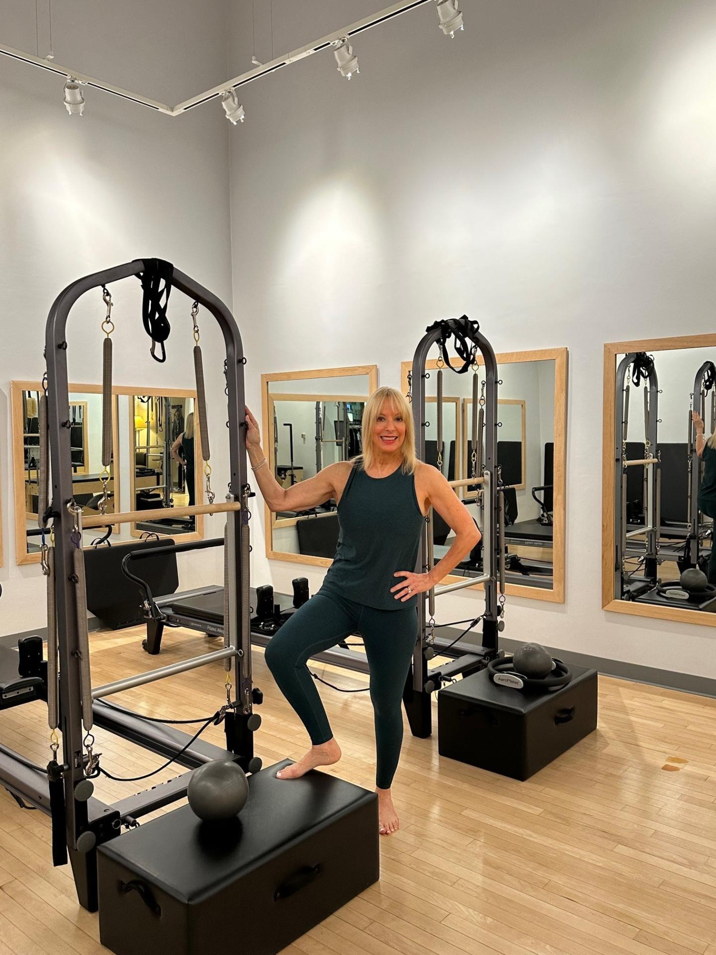 Angela Moore Pilates instructor with equipment in a studio setting.