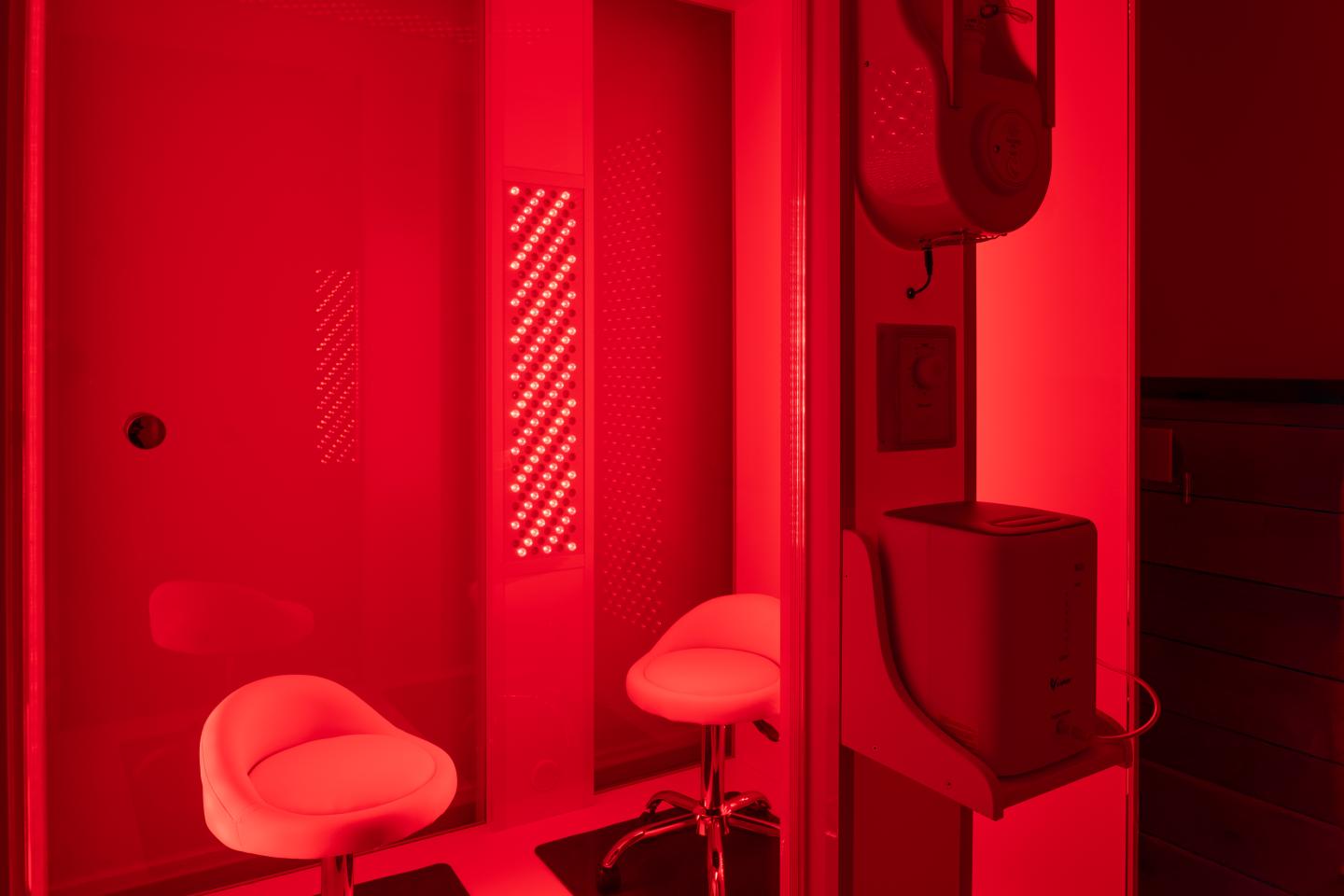 Bright red lit room with two stools and electronic equipment.