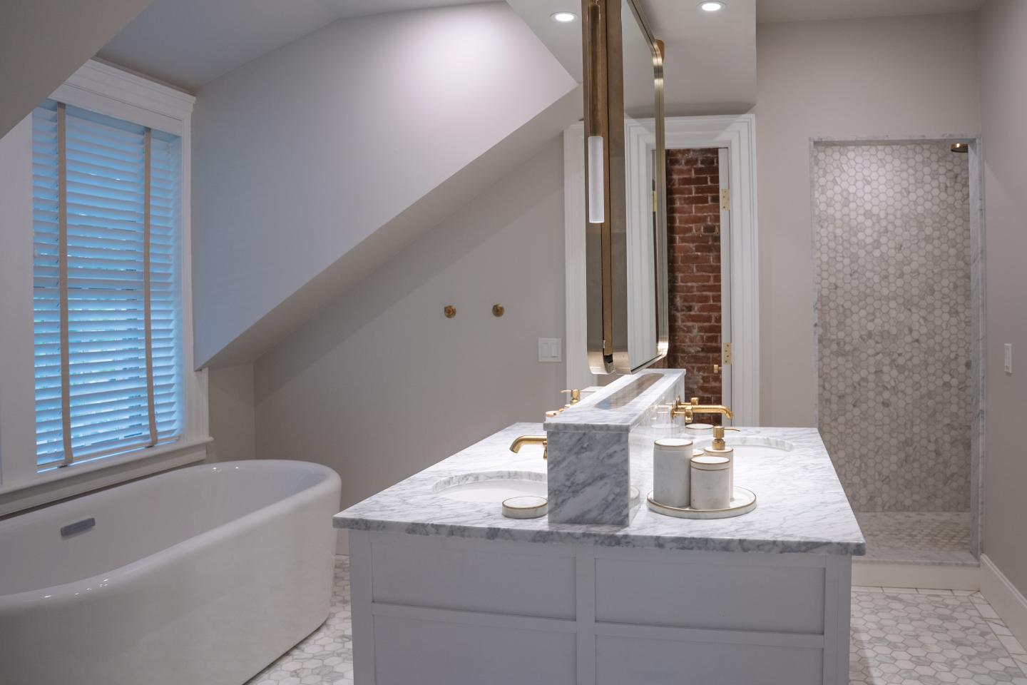 Modern bathroom with freestanding tub, marble vanity, and walk-in shower.